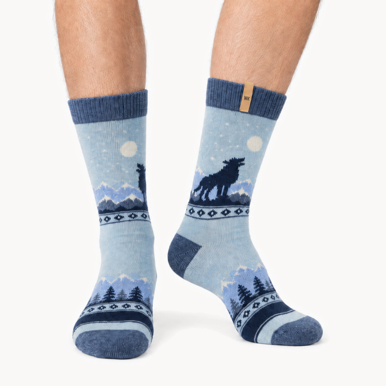 Midnight Howl merino wool crew socks for men, a wolf howling at the moon over a mountain range in four shades of blue