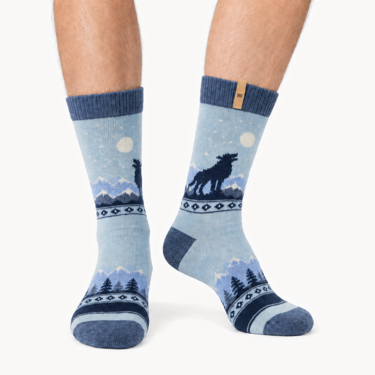 Midnight Howl merino wool crew socks for men, a wolf howling at the moon over a mountain range in four shades of blue